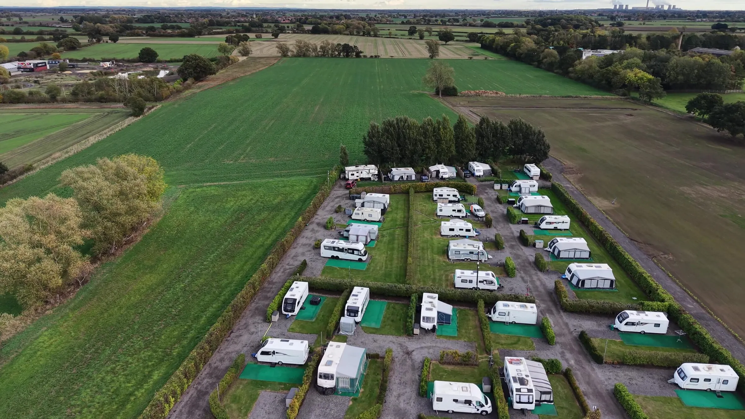 The pitches running towards a line of trees, with open farmland on both sides